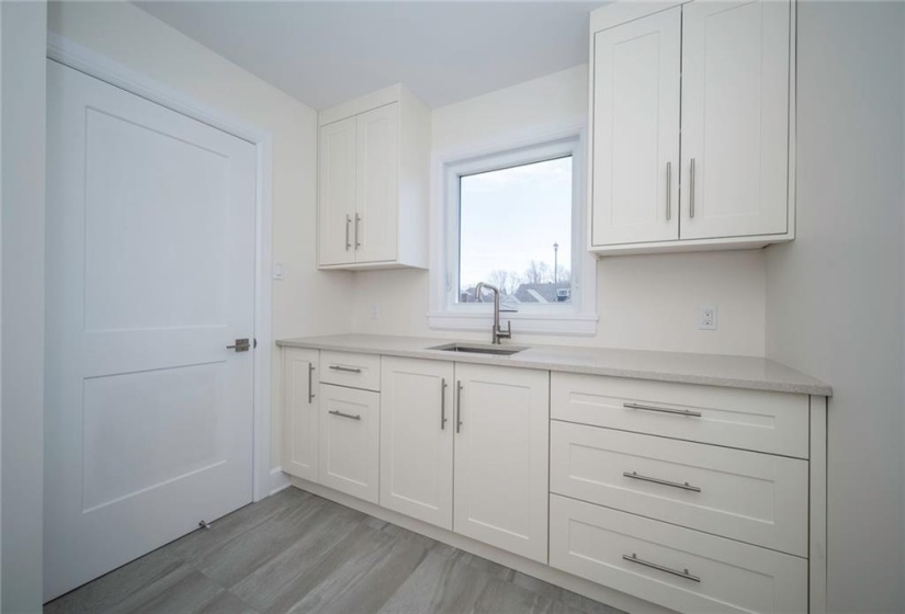 Main floor laundry room with a generous amount of cabinets for storage