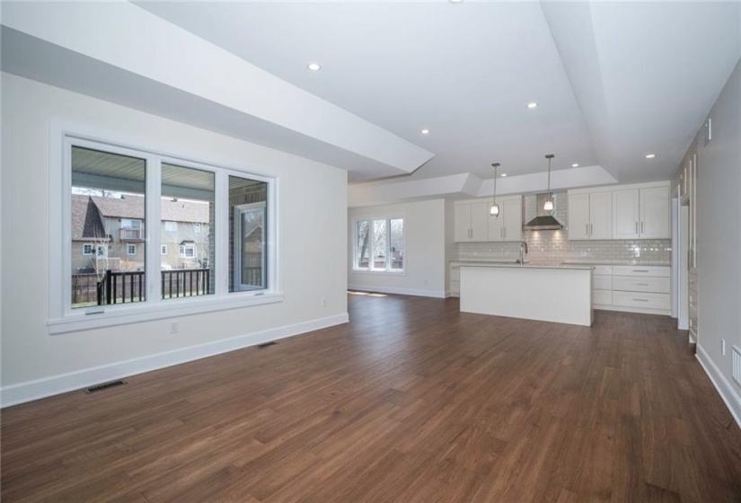 Open concept living room/kitchen/dining room finished with  beautiful wood floors