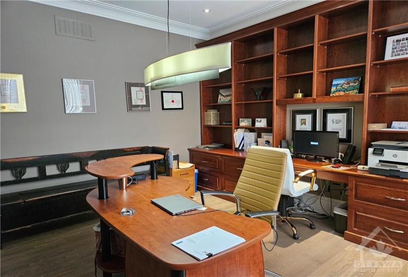 In this home office you will be proud to meet your clients if need be. It is conveniently located off the front foyer. The built-in library and custom desk with hidden keyboard shelf and file drawers is also large enough to be shared space as well.