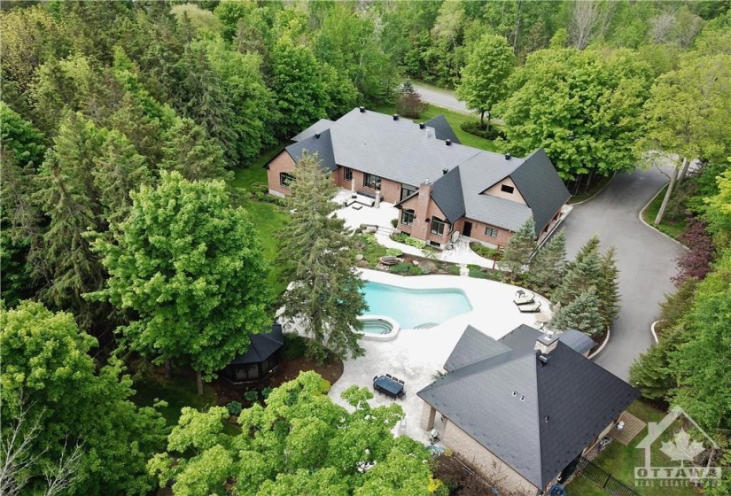 This aerial photo allows you to appreciate the beauty of this home and the property that surrounds it. The landscaping with tremendous easy to care for perennials including gorgeous Hostas and Grasses. The gardens both front and back give so much lush greenery to enjoy along side the huge trees everywhere.