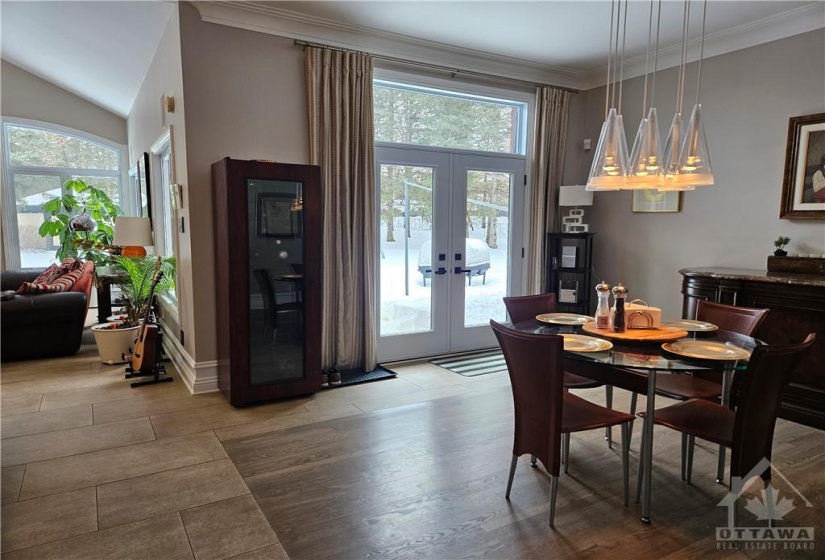 This is a view of the eating area in the kitchen for everyday dining. The double doors lead to a patio and gas outlet for a BBQ is a few steps away from the kitchen for easy entertaining. The kitchen and main floor family room have ceramic tile & radiant heated flooring.