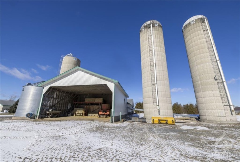 Two 20' x 80' concrete silos for corn silage, feed-room for loading dry-hay and straw onto the conveyor.
