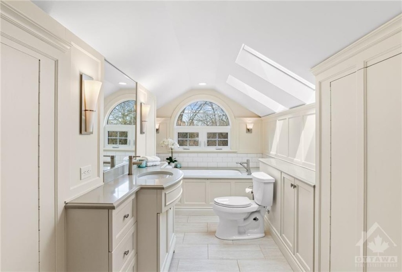 Renovated ensuite bathroom with quartz counters and soaker tub.