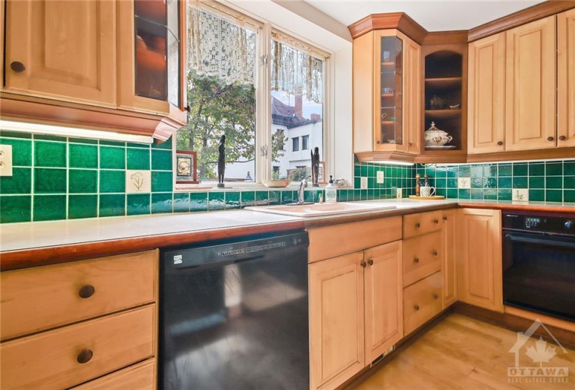 Renovated Kitchen with some show case cabinets, crown mouldings, valance lighting. Sink overlooks rear garden/fenced yard.