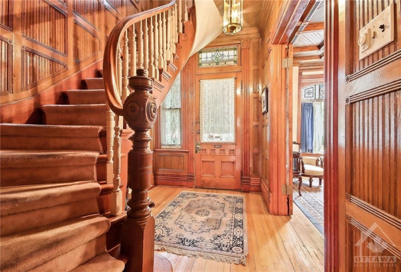 Rich wood panelling incases a spacious front entrance, curved staircase leading to second floor. Note the exeptional , detailed wood finishings. A period craftsman delight.