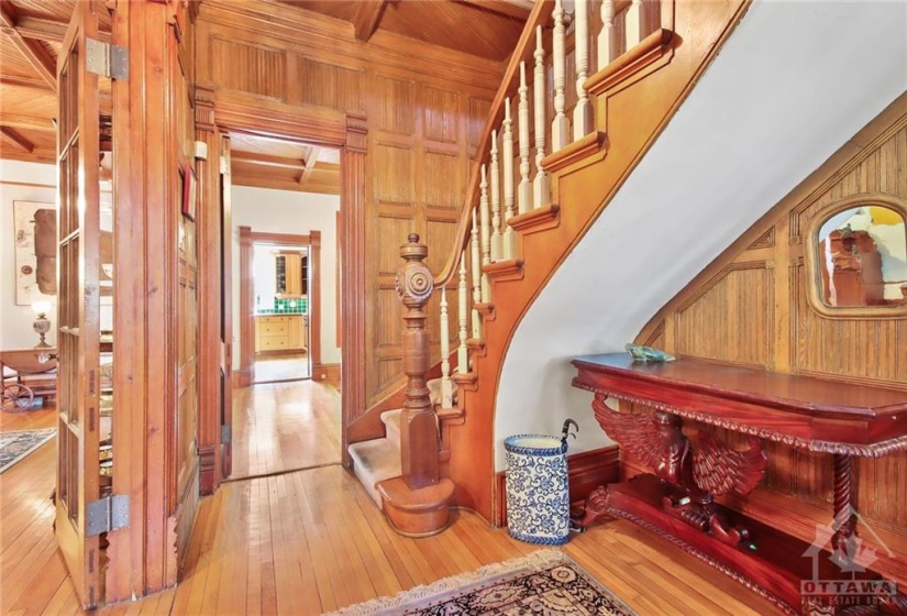 Spacious front hallway entrance with curved wood stairscase, access to the living room and the rest of the 1st level. Note the intricate rich wood designs plus the high ceilings.