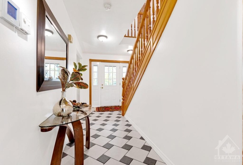 Welcoming you home is white bright foyer with dramatic tiled floor
