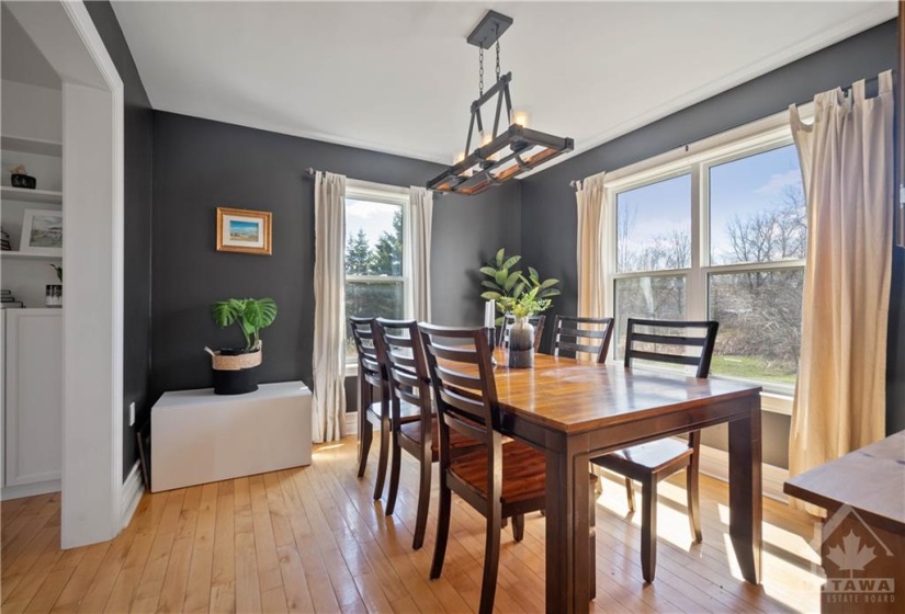 Sunlit dining room with upgraded lighting and a spectacular view of the private backyard space.