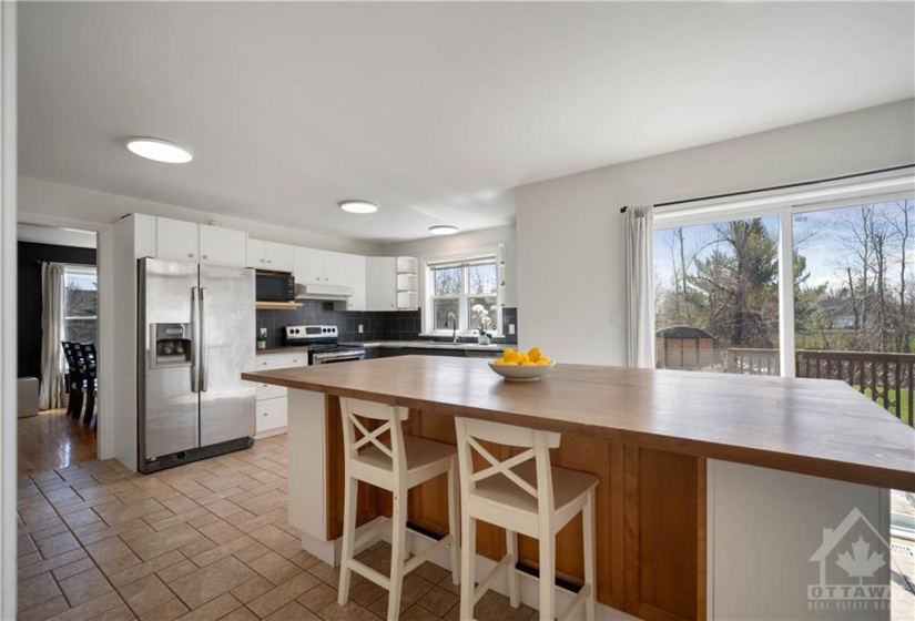 The heart of the home lies within the spacious kitchen, boasting ample cabinetry and wood countertops, catering to the needs of culinary enthusiasts.