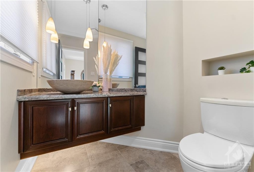 Gorgeous high end powder room situated inside the front door.  High end fixtures including stone basin and floating vanity.