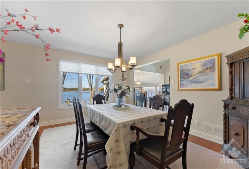 Beautiful dining room situated behind the kitchen and overlooks the water.  There is a staircase in the left hand side that goes upstairs to the guest and children's bedrooms.