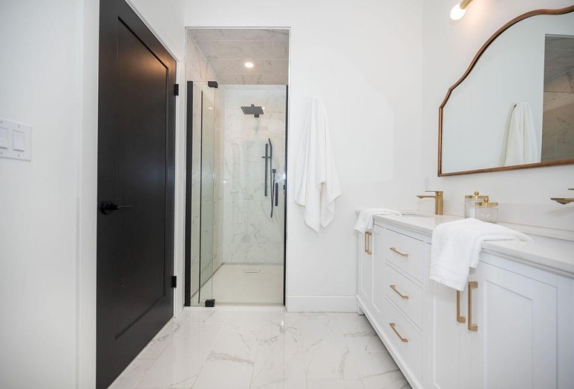 Walk-in shower with rain shower head and vanity with double sinks