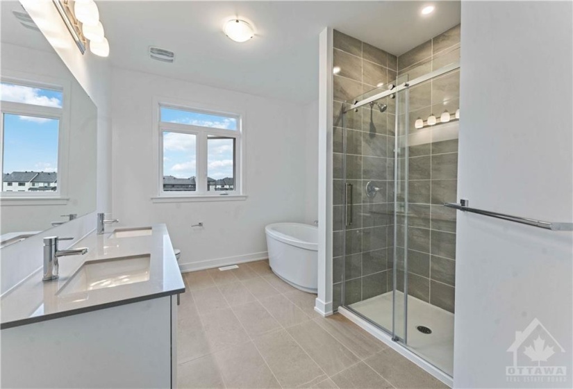 Luxury ensuite with double sink vanity, quartz counters, stand  alone tub, glass/ceramic shower and upgraded tile