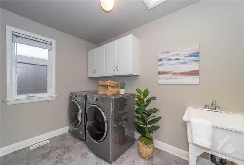 The very convenient 2nd level laundry room is incredibly spacious, and features a washer & dryer, tub, and cabinetry.