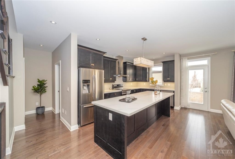 Updated quartz counters, stainless steel appliances, and plenty of cabinetry make this kitchen a chef's delight! Imagine entertaining from behind the island while guests look on!