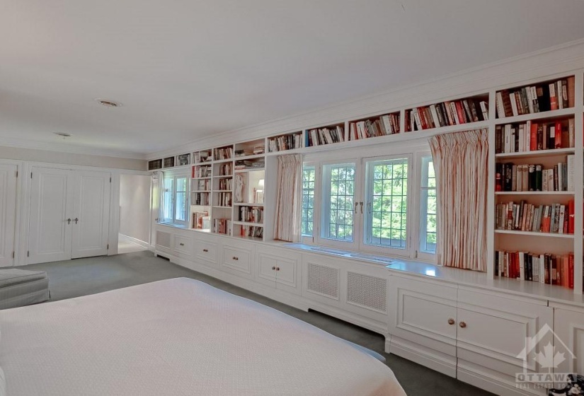 Built-in shelving and cupboards in primary bedroom.