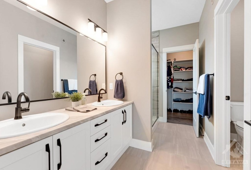 Spa ensuite with two-sink vanity and separate water closet