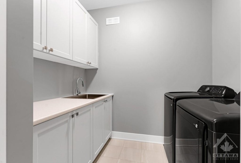 Laundry room with sink and storage cabinets