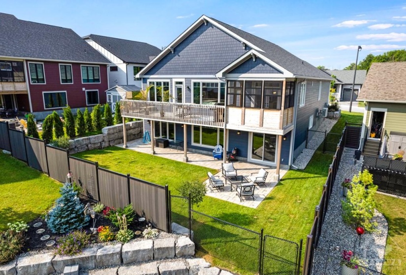 Upper deck and lower patio overlooks fenced yard that backs onto parkette with pond and walkway.