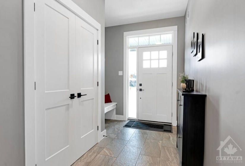 Inviting front foyer has closet, built-in bench and retractable screen on door