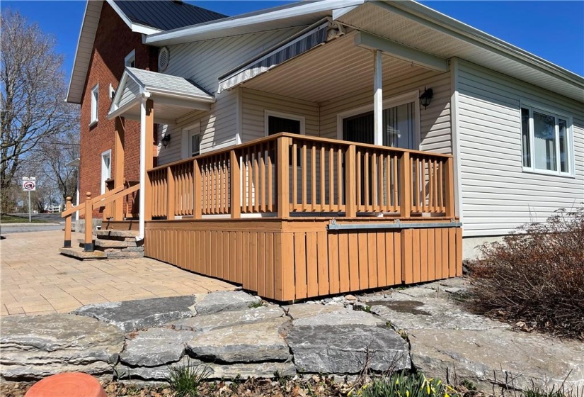 Uni pave drive way, landscaped flower garden, deck for outdoor dining with  awning over head