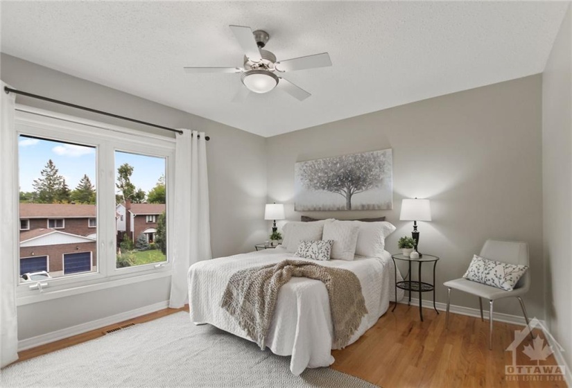 Primary suite with hardwood flooring and fresh paint.