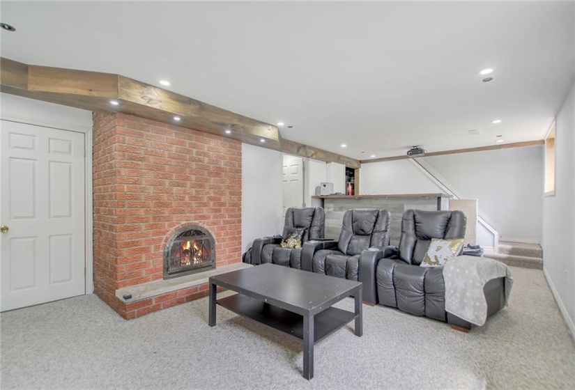 Lower level family/entertainment/home theatre room with double sided fireplace