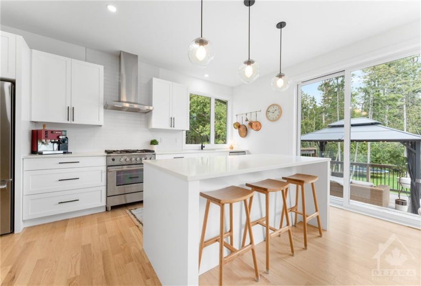 Stunning Modern White Kitchen w/Black Accents w/Lg Island & Breakfast Bar w/Modern Pendants, Quartz Counters, Tile Backsplash Pantry, SS Appliances w/Gas Stove & Range Hood & Extra Window Added w/Tree Views from every Angle