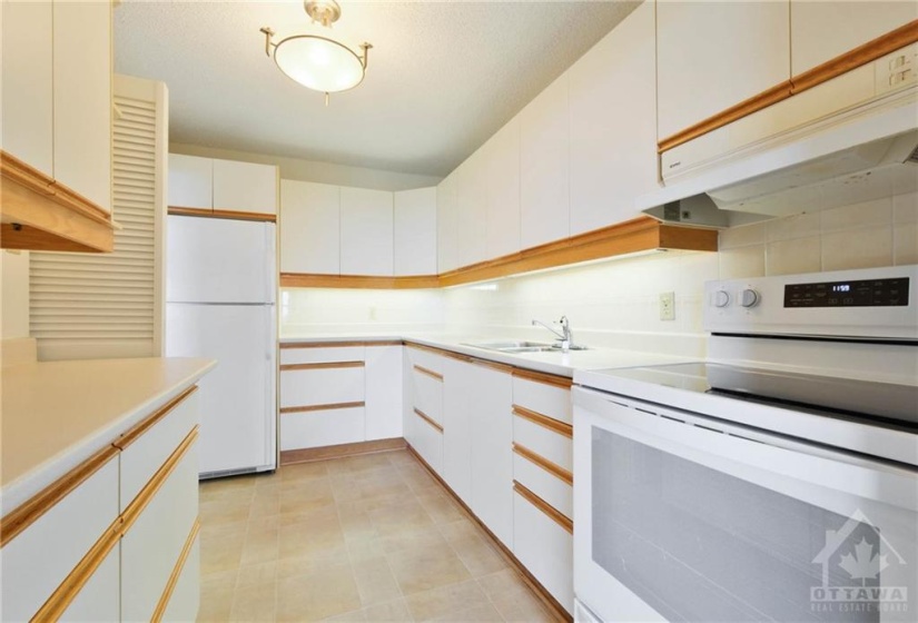 Kitchen has lots of cabinetry and counter space.