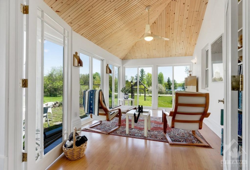 Vaulted sunroom has walls of sliding glass patio doors