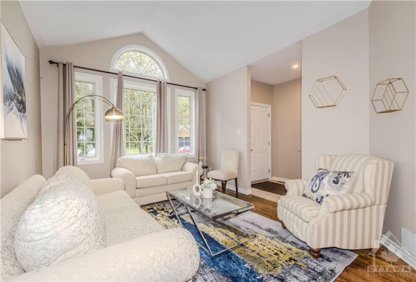 living room with vaulted ceiling and large windows