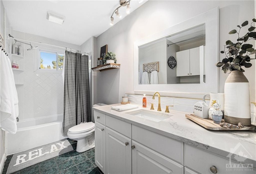 Zippy bath/laundry room with jazzy brass vanity fixtures and granite counter