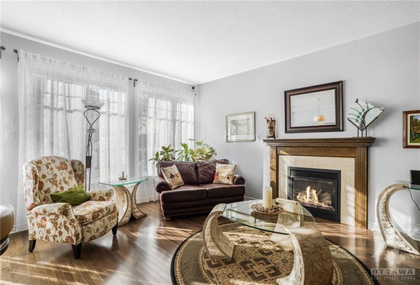 Living room with 9 foot ceilings, hardwood floors & gas fireplace