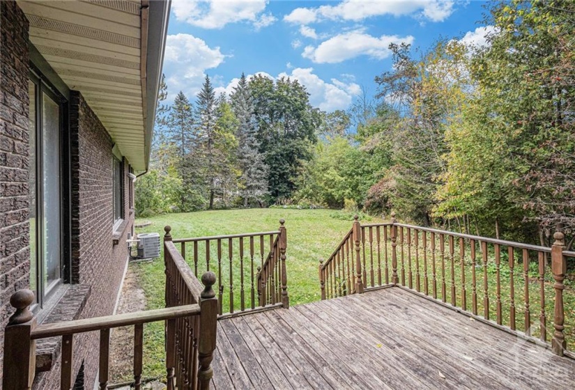 Deck leads to very large backyard overlooking the river