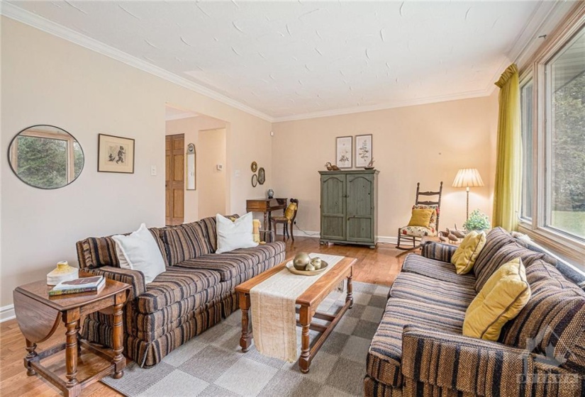 Generously sized living room with large window and wood burning fireplace