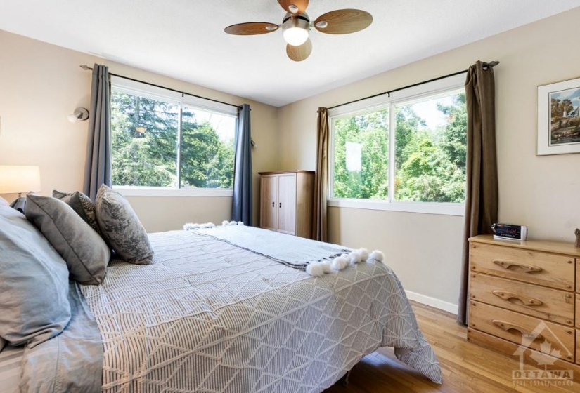 Primary bedroom large windows overlook picturesque yard