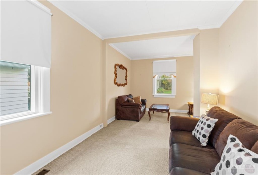 Long and spacious living room w/ carpet floors. Original Hardwood floors underneath.