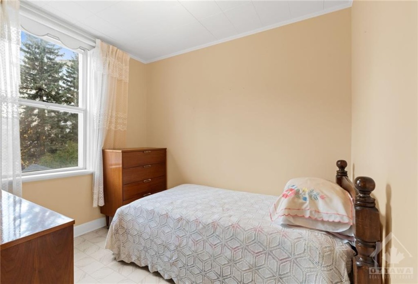 Bedroom w/ closet & window facing the backyard.