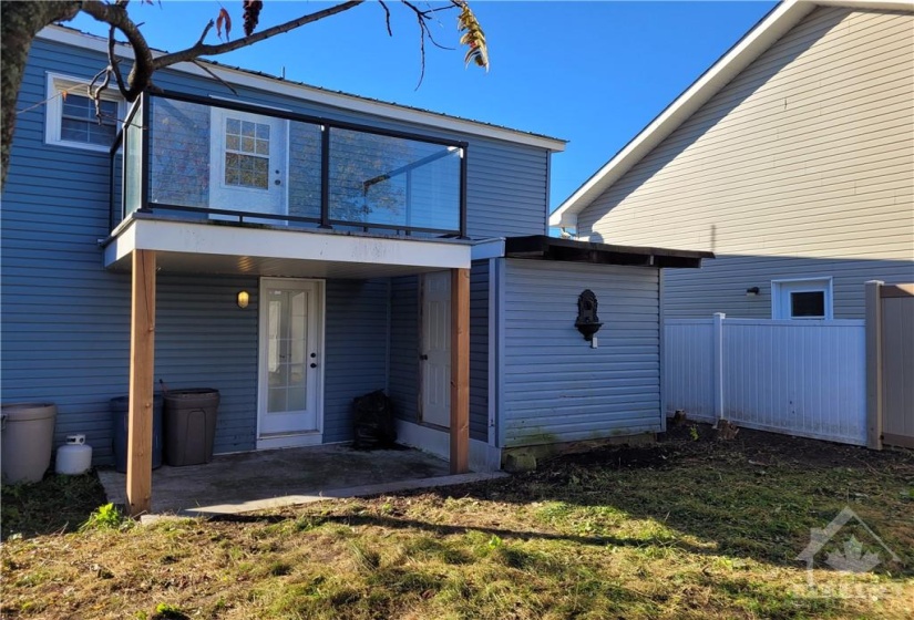 View of the back of the house and balcony. The door beside the back door is to  a small attached storage shed.