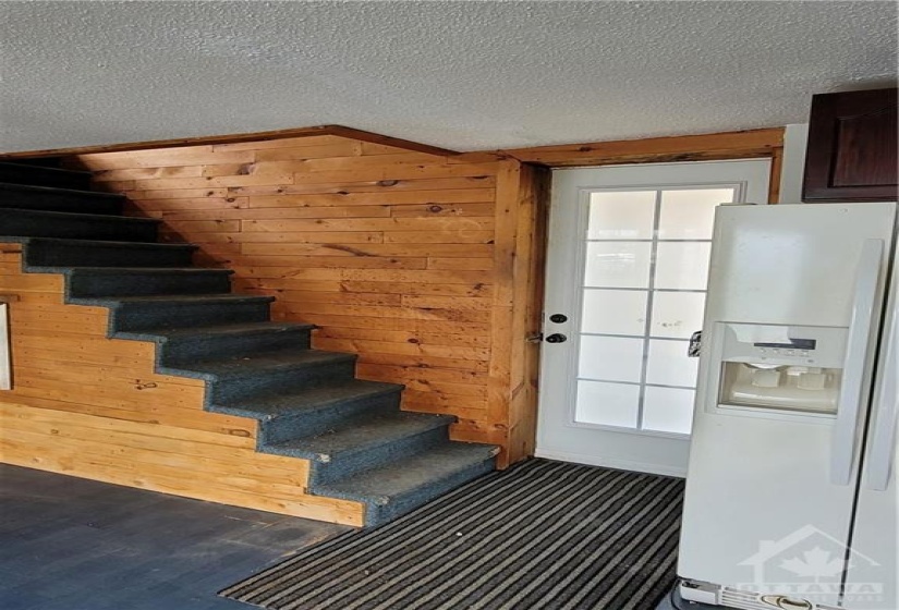 Stairs to the upper level and back door leading to the yard.