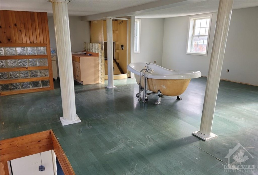 The second level viewed from the top of the stairs - one large room with the 2 pc bathroom in the corner. The shower stall is beside the bathroom with the tub in front.