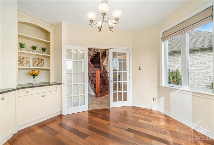 A charming den with French doors is set in the home's unique turret, perfect for a home office or study.