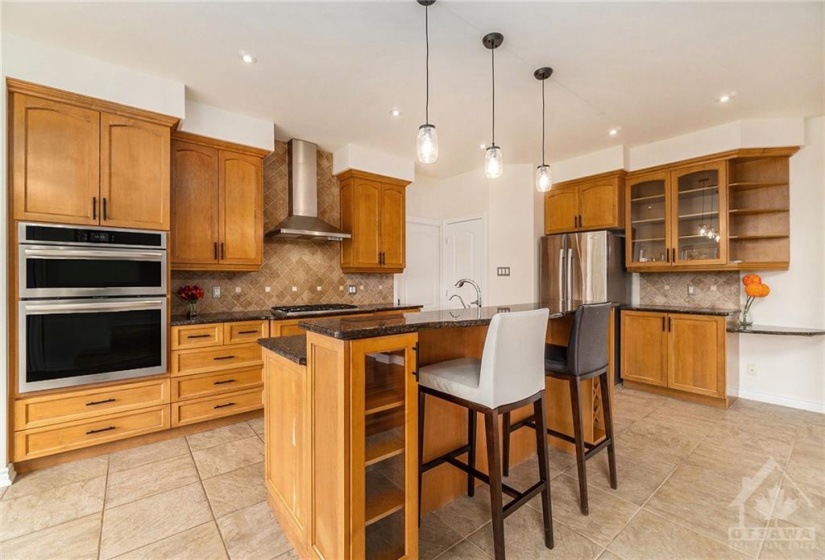 The spacious kitchen is a chef’s dream, offering sleek stainless steel appliances, a pantry, and a convenient breakfast bar.