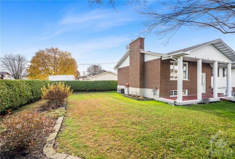 Side yard with flower beds and notice that this quality home offers brick on this side also. Notice the perfectly trimmed hedge offering full privacy.