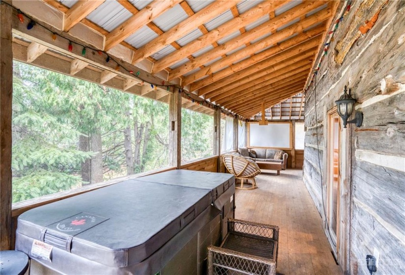 Side portion of wrap around porch with hot tub in the foreground