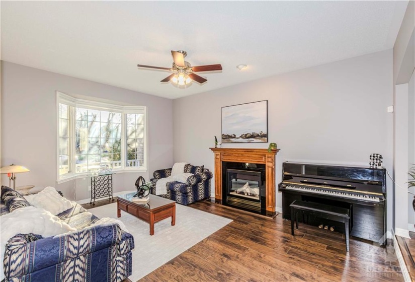 Main floor living room with fireplace and bay windows